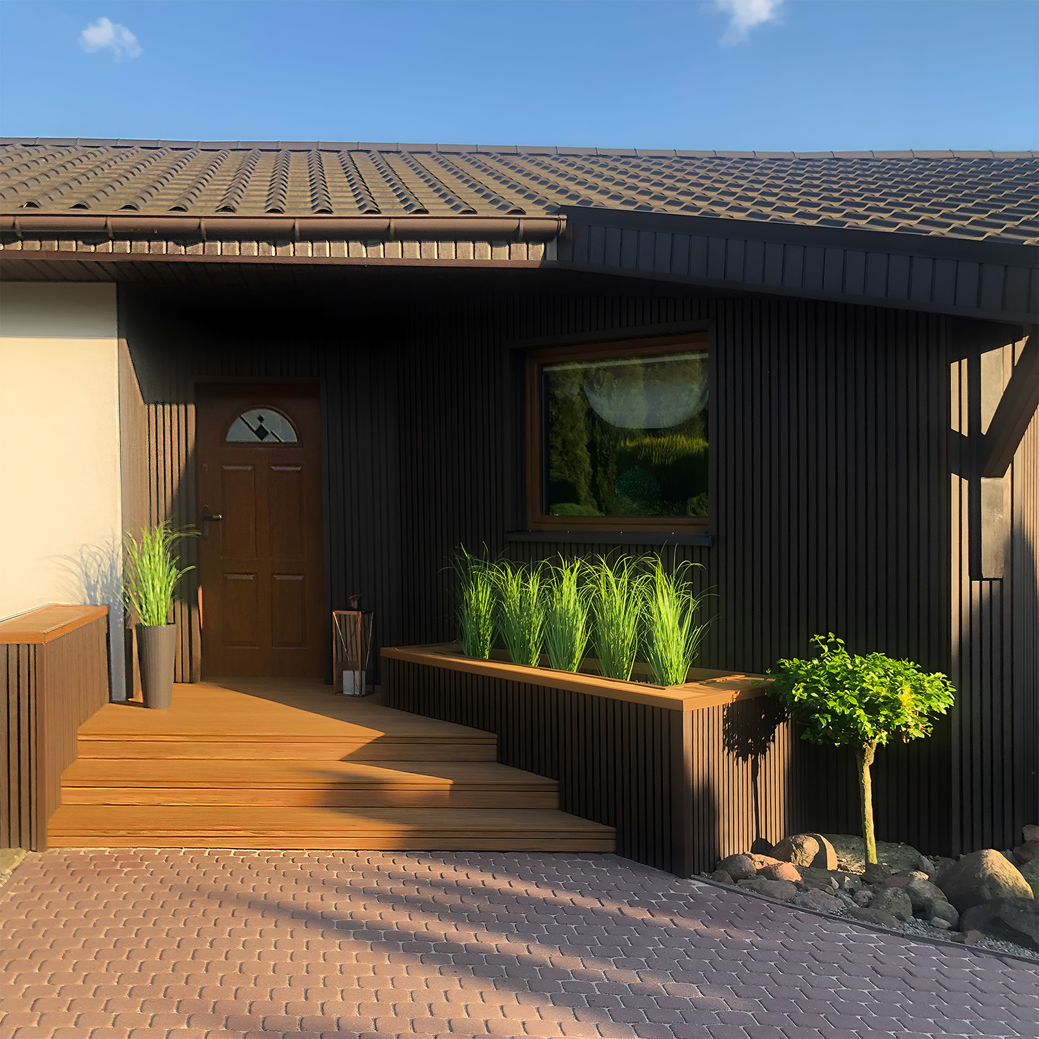 Taras i elewacja kompozytowa: Lamele 3D Premium Walnut i deska tarasowa Premium Amber